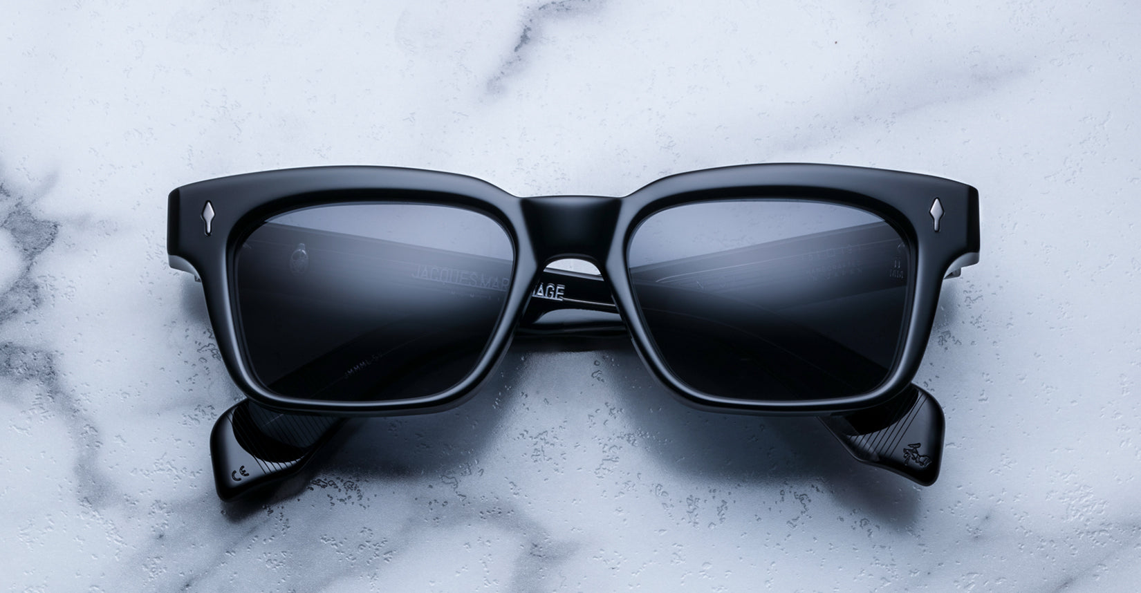 Jacques Marie Mage Molino Vanta sunglasses with black frames and clear lenses, front view showing sleek, modern design.