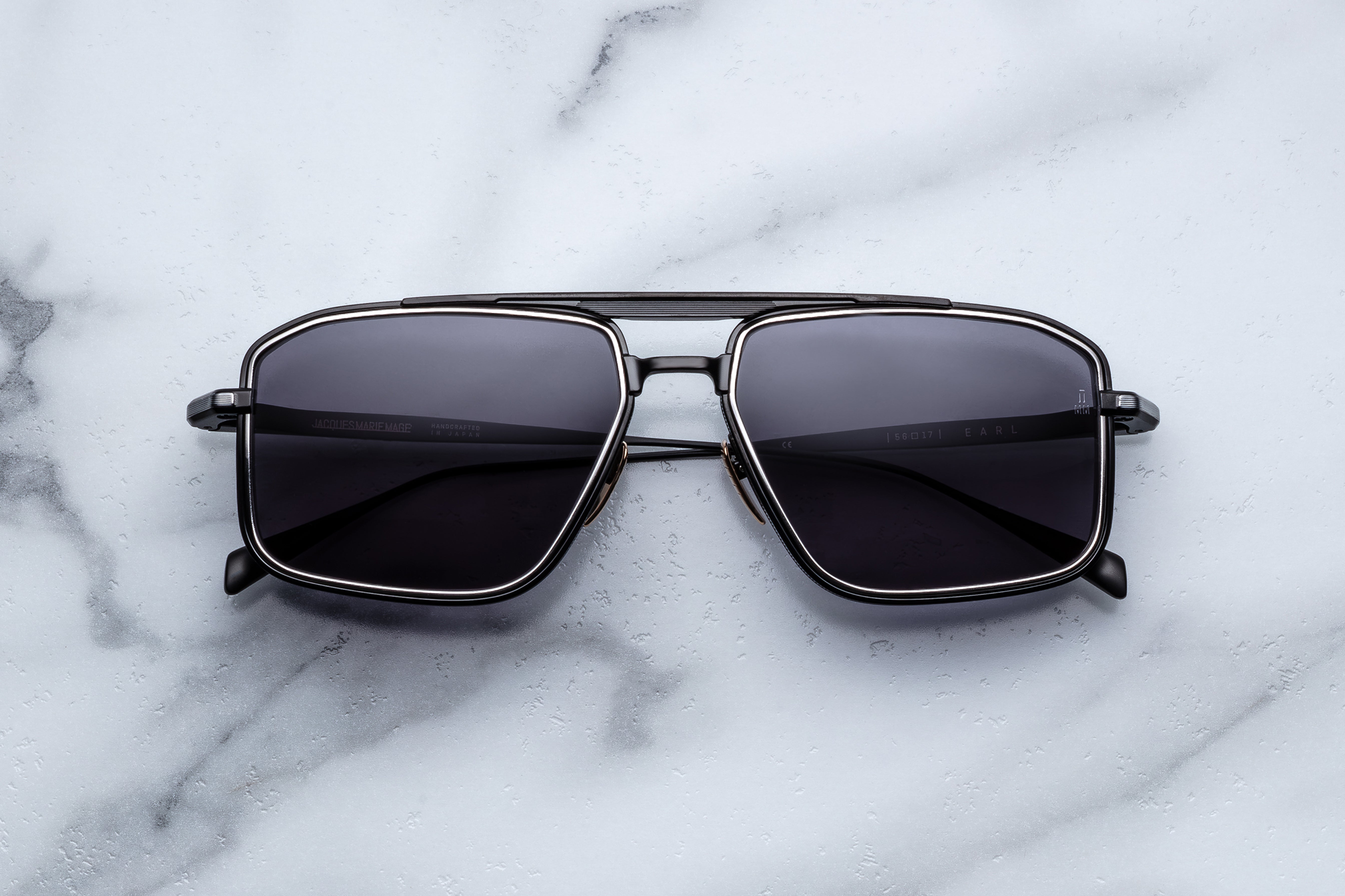 Jacques Marie Mage Earl sunglasses with clear frames and dark lenses, close-up front view showcasing stylish eyewear design.