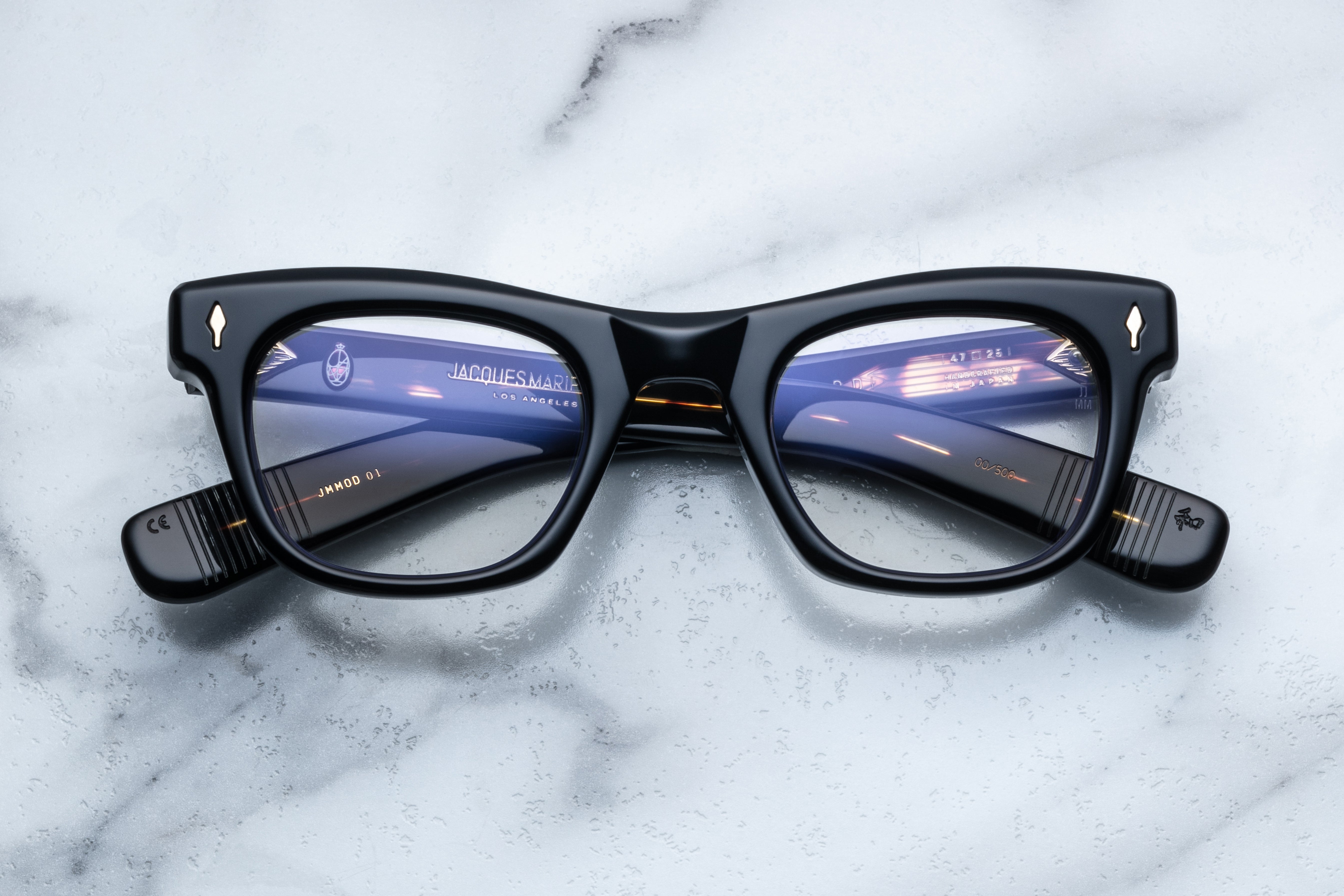 Jacques Marie Mage Godard Noir RX optical glasses with black frames and clear lenses, close-up front view.