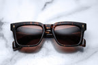 Jacques Marie Mage Torino sunglasses with dark tinted lenses and sleek black frame on a white background