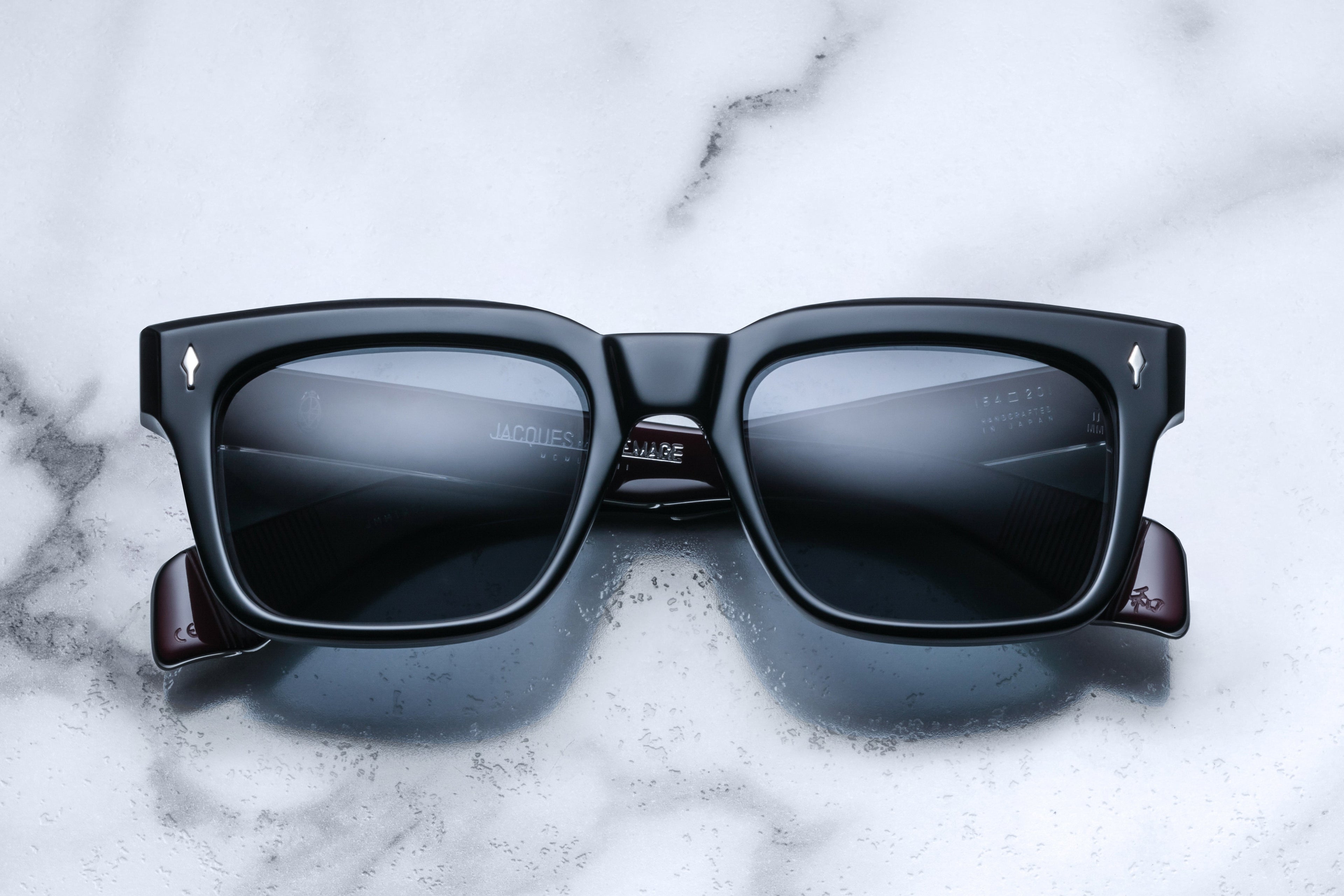 Jacques Marie Mage Torino sunglasses with dark tinted lenses and sleek black frames on a white background.