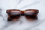 Jacques Marie Mage Molino 55 sunglasses with bourbon-colored frames and clear lenses, shown from a front view.