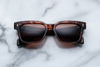 Jacques Marie Mage Molino 55 sunglasses with sleek black frames and tinted lenses, front view showing stylish design details.