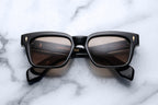 Jacques Marie Mage Molino Eclipse sunglasses with round black frames and tinted lenses, front view.
