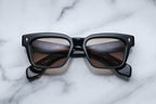 Jacques Marie Mage Molino Noir sunglasses with rounded black frames and clear lenses, front view.