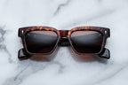 Jacques Marie Mage Molino Samoa sunglasses with rounded frames and dark lenses, shown from the front.