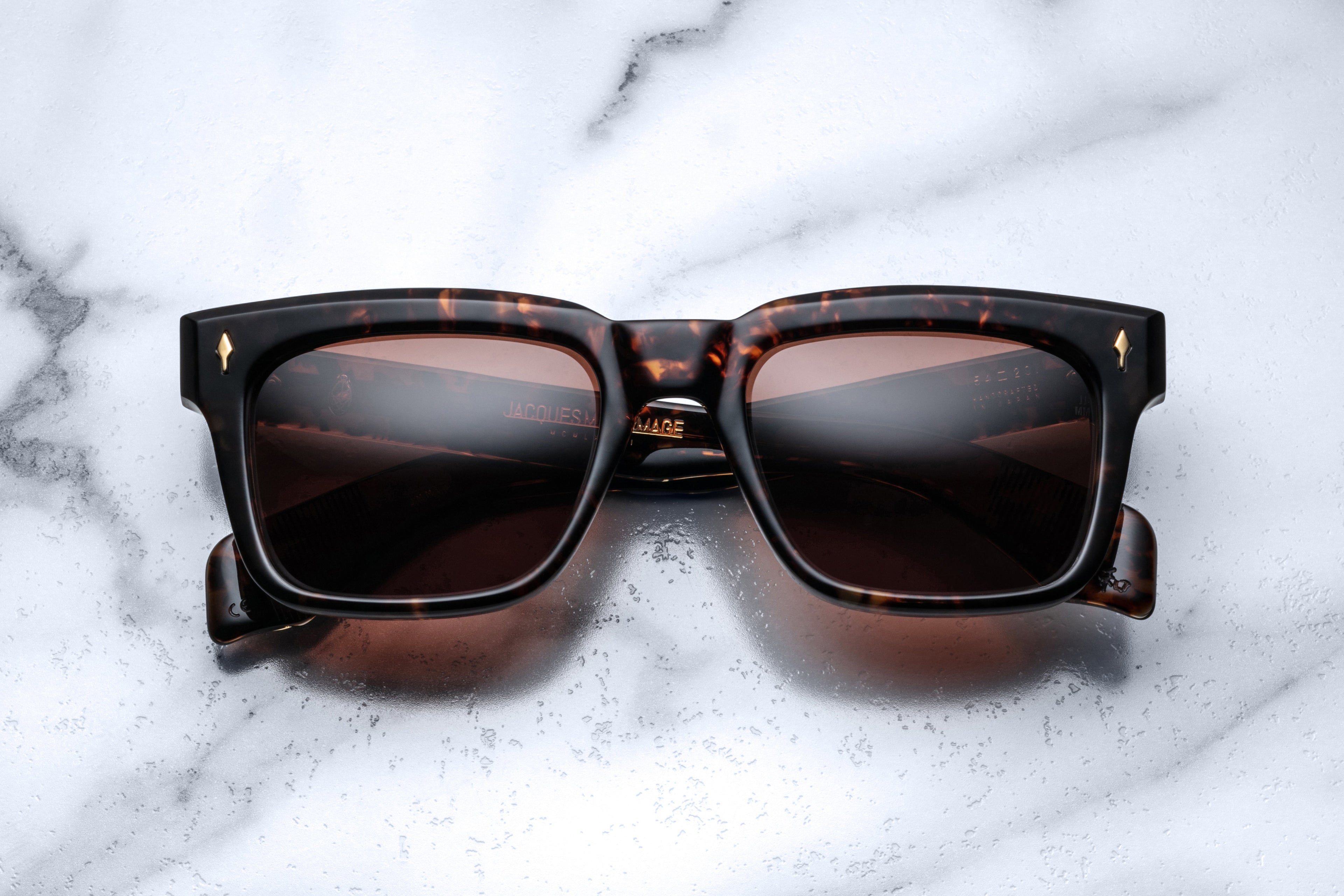 Jacques Marie Mage Torino sunglasses with round agar-colored lenses and sleek black frame, front view.