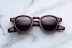 Jacques Marie Mage Zephirin Bordeaux sunglasses with rounded frames and dark tinted lenses, front view image.