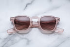 Jacques Marie Mage Zephirin sunglasses with peach-colored frames and clear lenses, shown from the front.